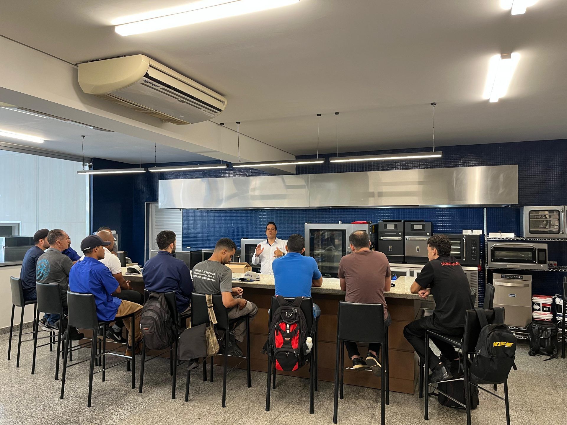 Um grupo de pessoas está sentado à mesa na cozinha.