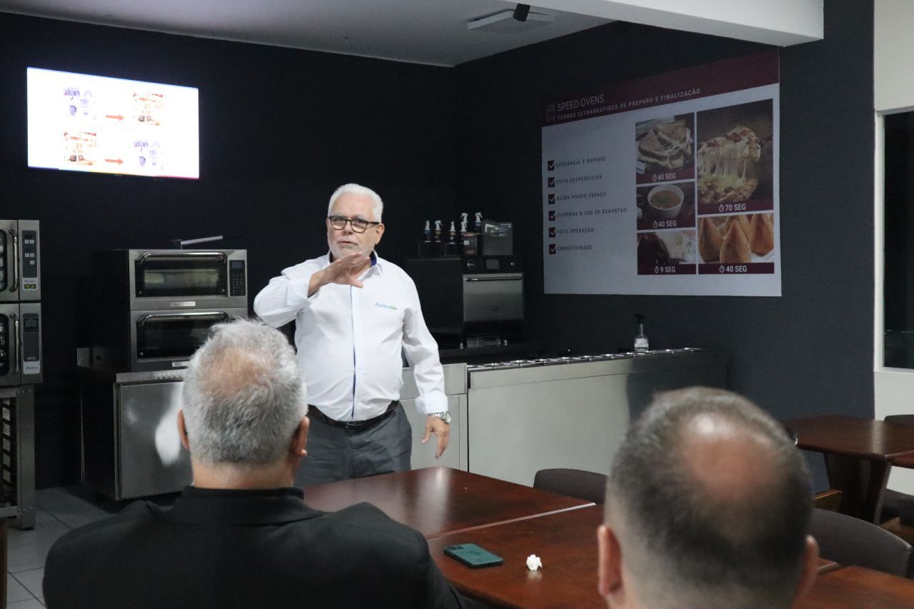 Um homem está fazendo uma apresentação para um grupo de pessoas em uma sala.