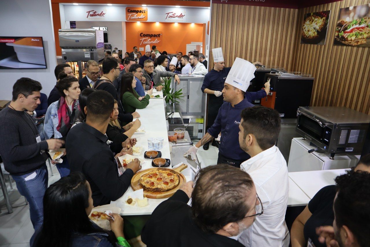 Um grupo de pessoas está comendo pizza em um restaurante.