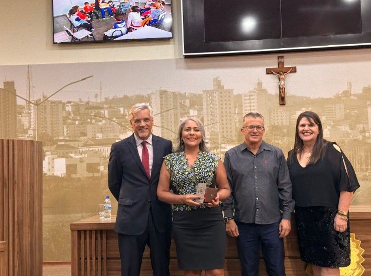 Um grupo de pessoas está de pé, uma ao lado da outra, em uma sala.