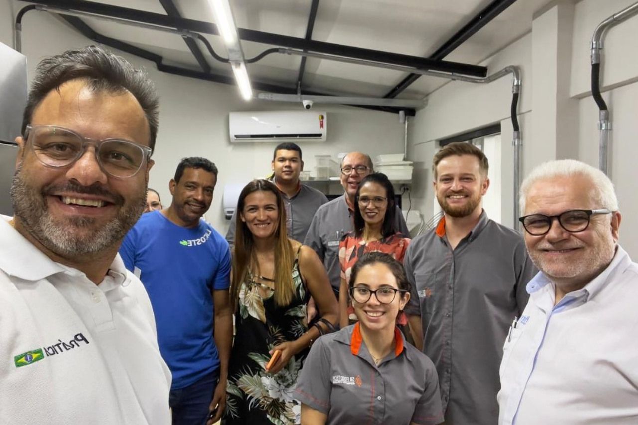 Um grupo de pessoas está posando para uma foto em uma sala.