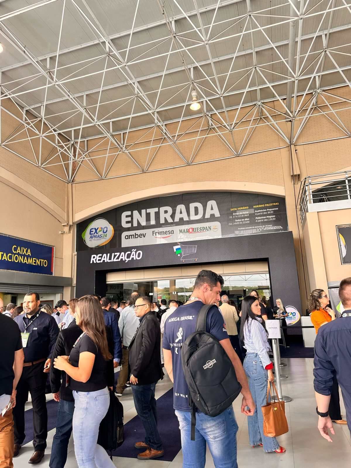 Um grupo de pessoas está em frente a uma placa que diz entrada.