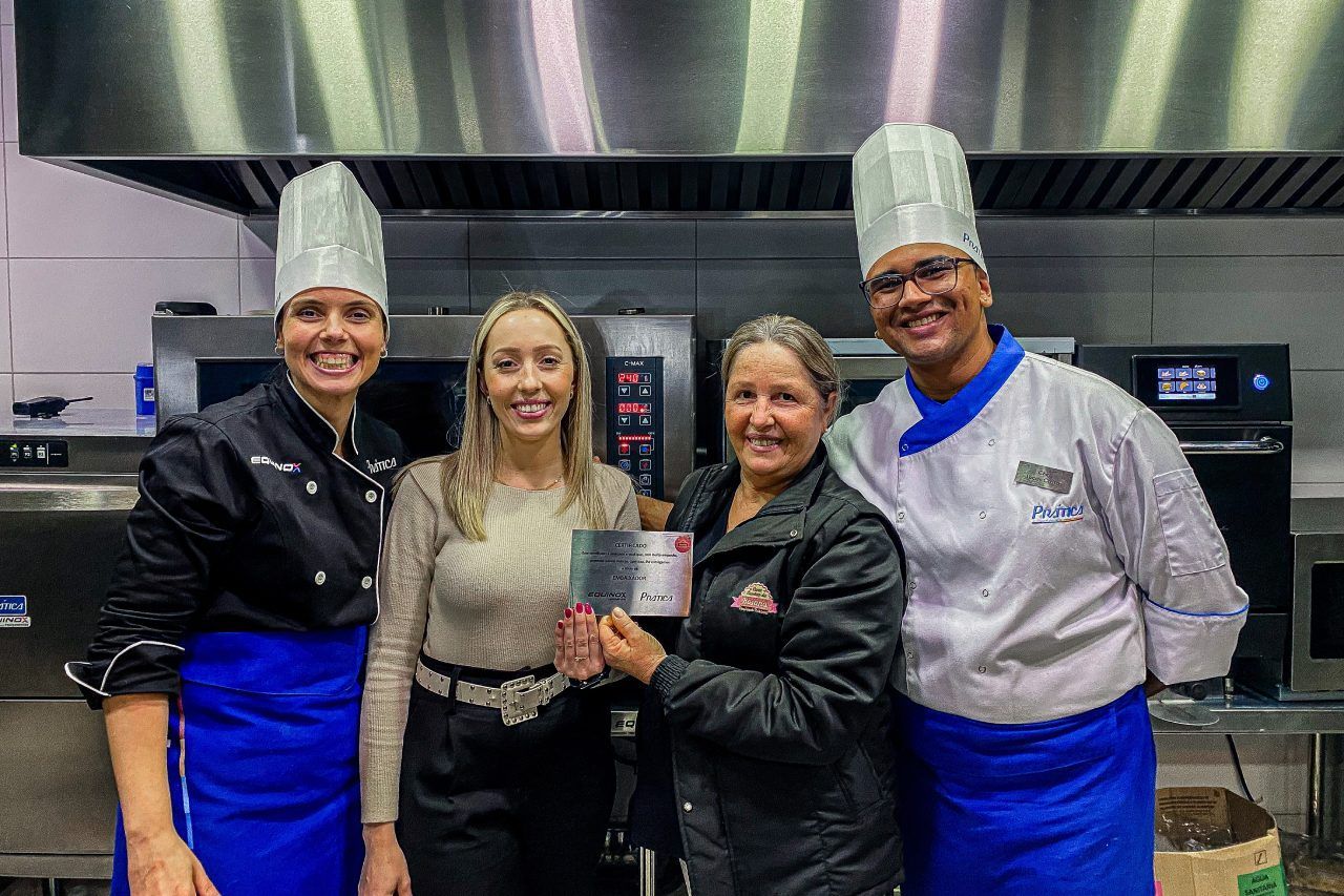 Um grupo de pessoas está posando para uma foto em uma cozinha.