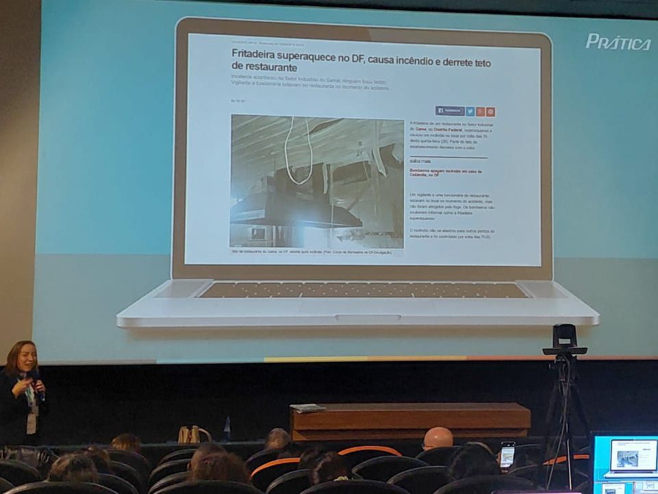 Uma mulher está fazendo uma apresentação em frente a uma tela de laptop