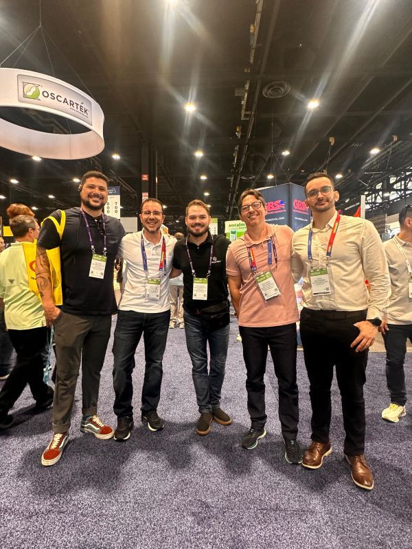 Um grupo de homens está posando para uma foto em uma convenção.