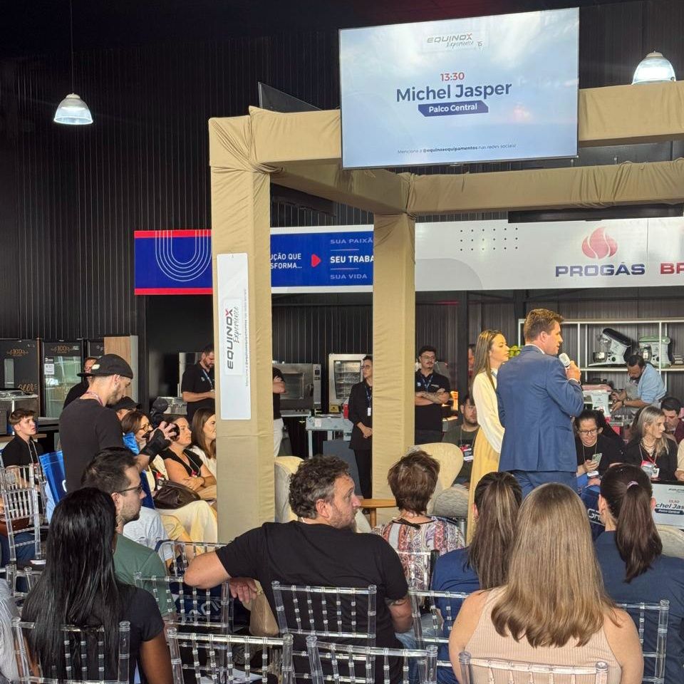 Um grupo de pessoas sentadas em frente a uma placa que diz michel jasper