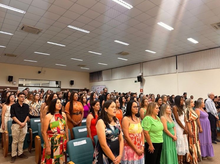 Um grande grupo de pessoas está em uma sala grande.