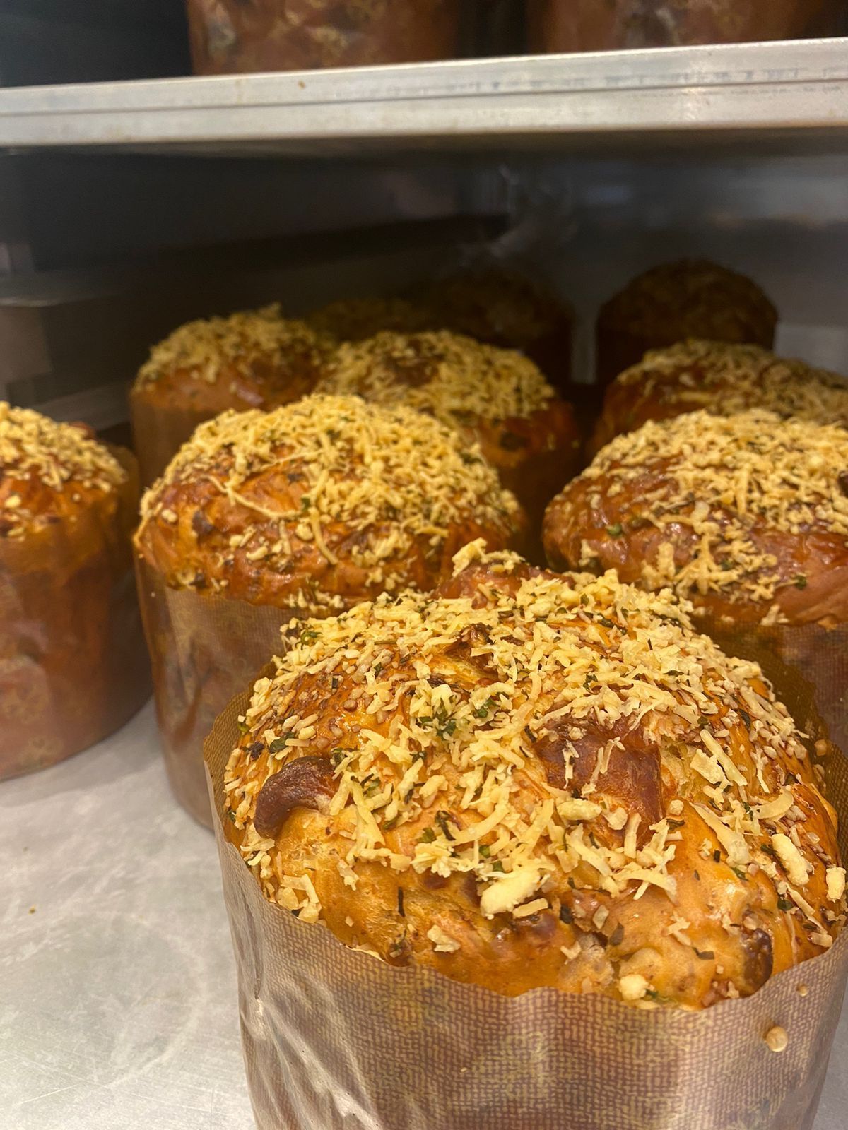 Um monte de muffins com queijo por cima estão sobre uma mesa.