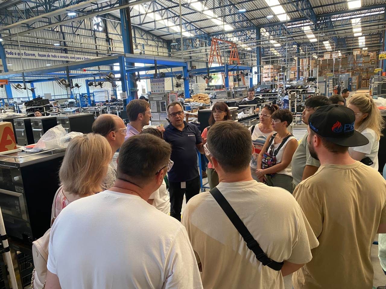 Um grupo de pessoas está em um armazém conversando entre si.