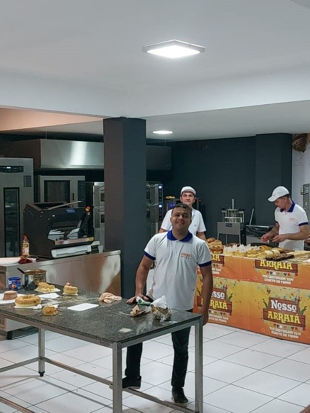 Um homem está de pé em frente a uma mesa na cozinha.