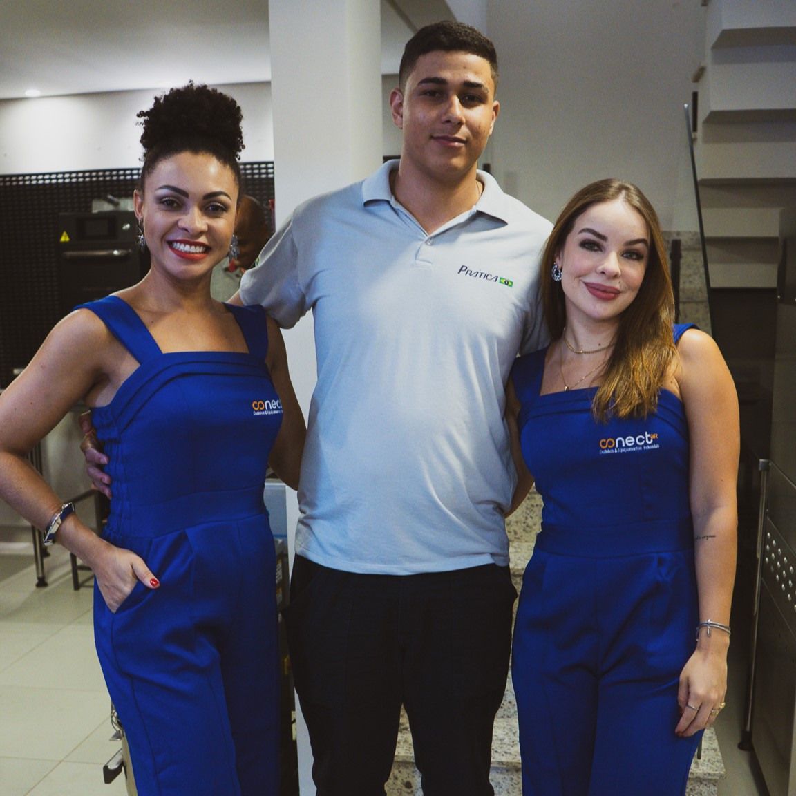 Um homem e duas mulheres estão posando para uma foto juntos