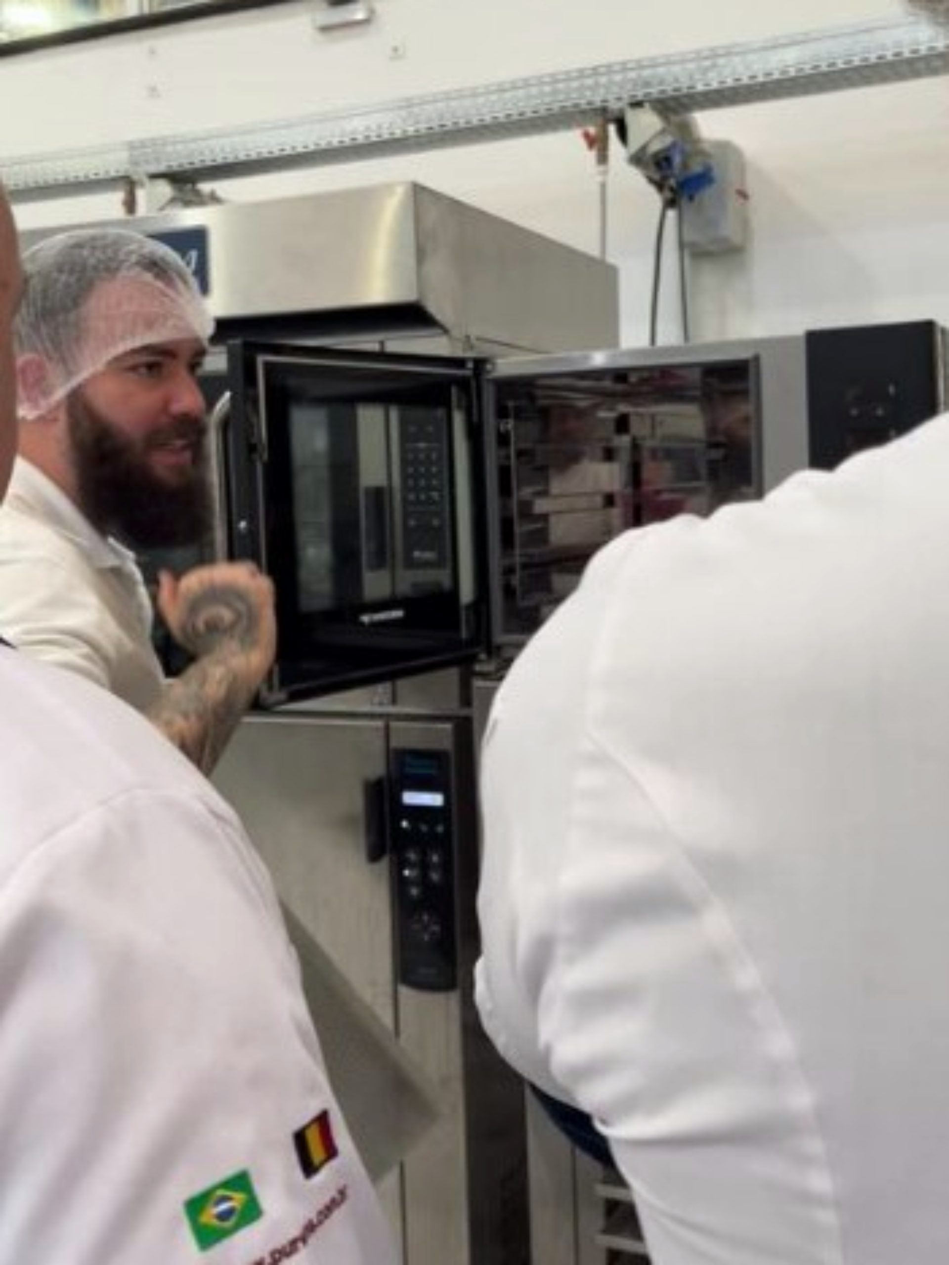 Um homem com uma tatuagem no braço está em frente a um micro-ondas