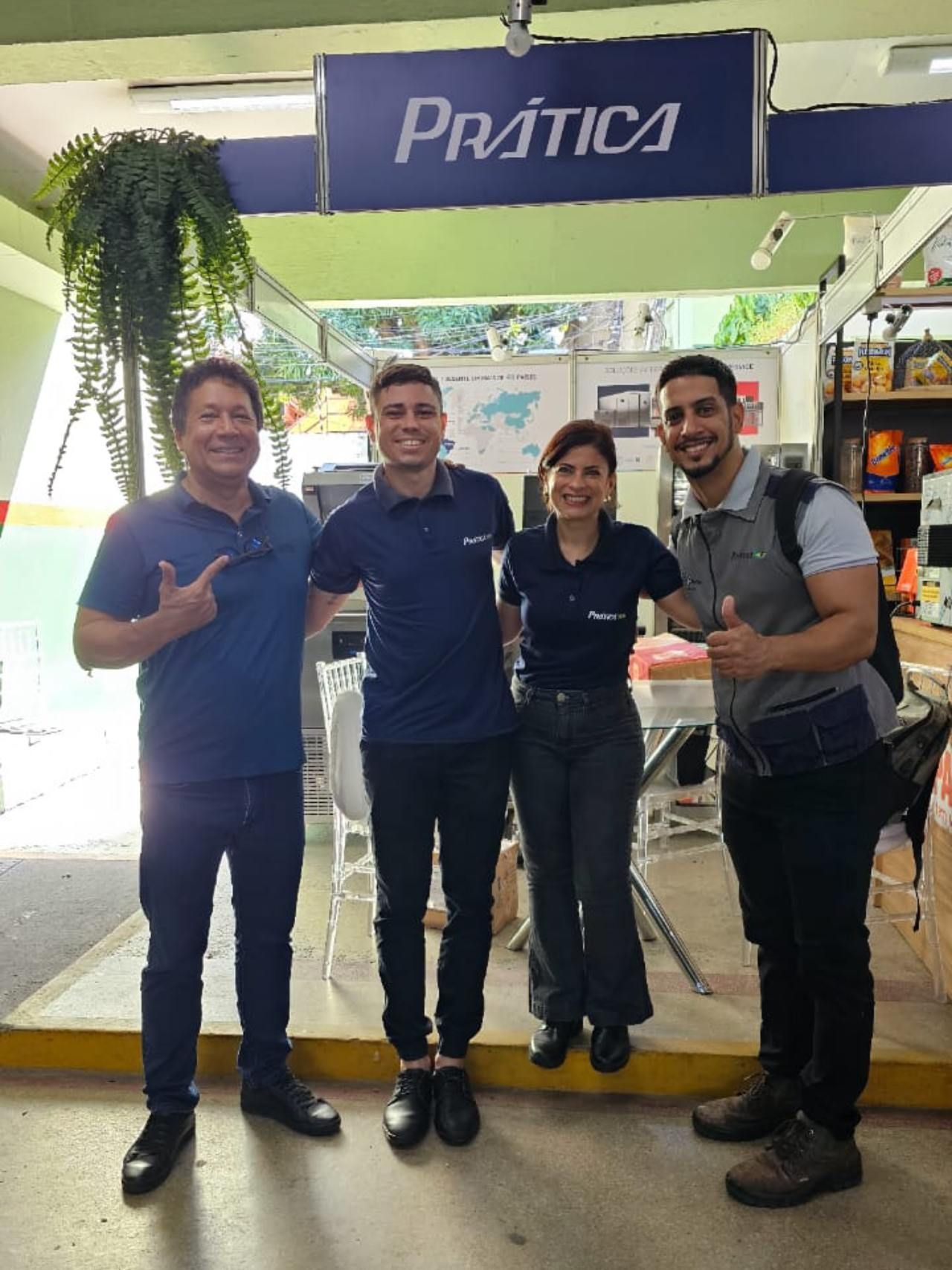 Um grupo de pessoas está posando para uma foto em frente a uma placa de prática.