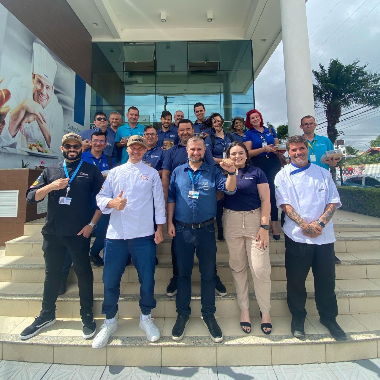 Um grupo de pessoas posando para uma foto em frente a um prédio