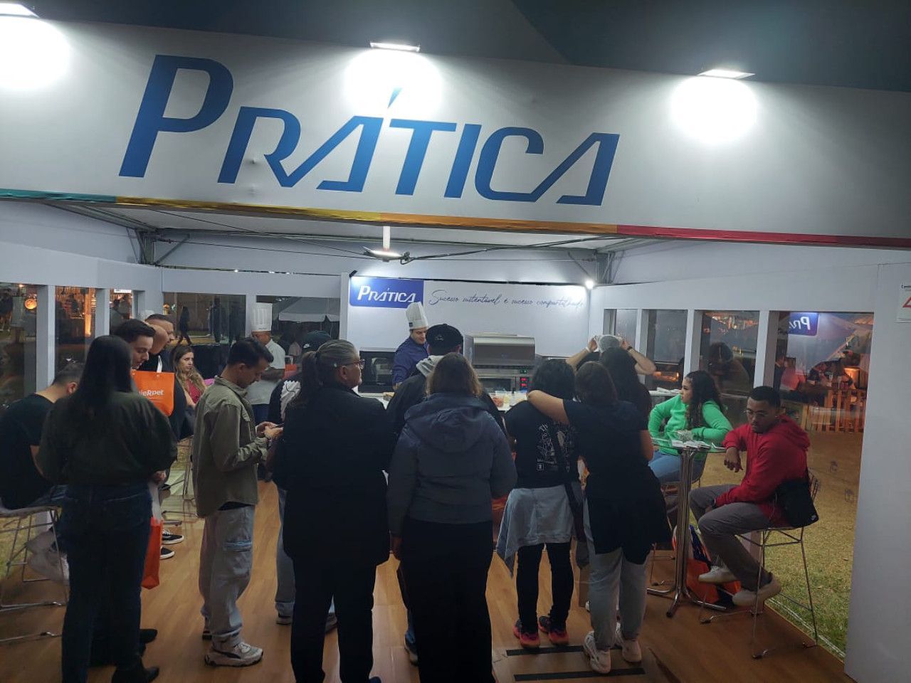 Um grupo de pessoas em pé sob uma placa que diz pratica