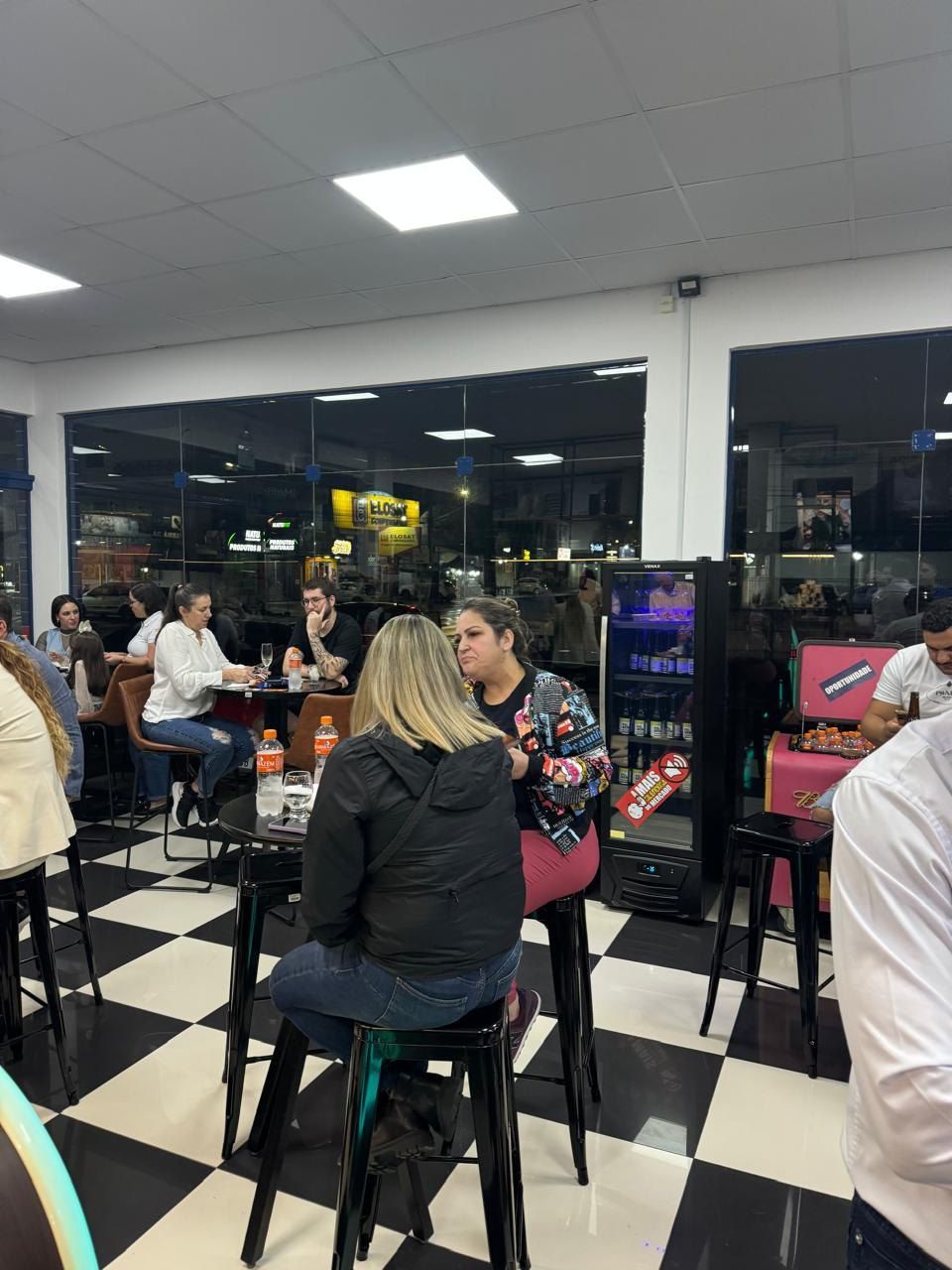 Um grupo de pessoas está sentado em mesas em um restaurante.