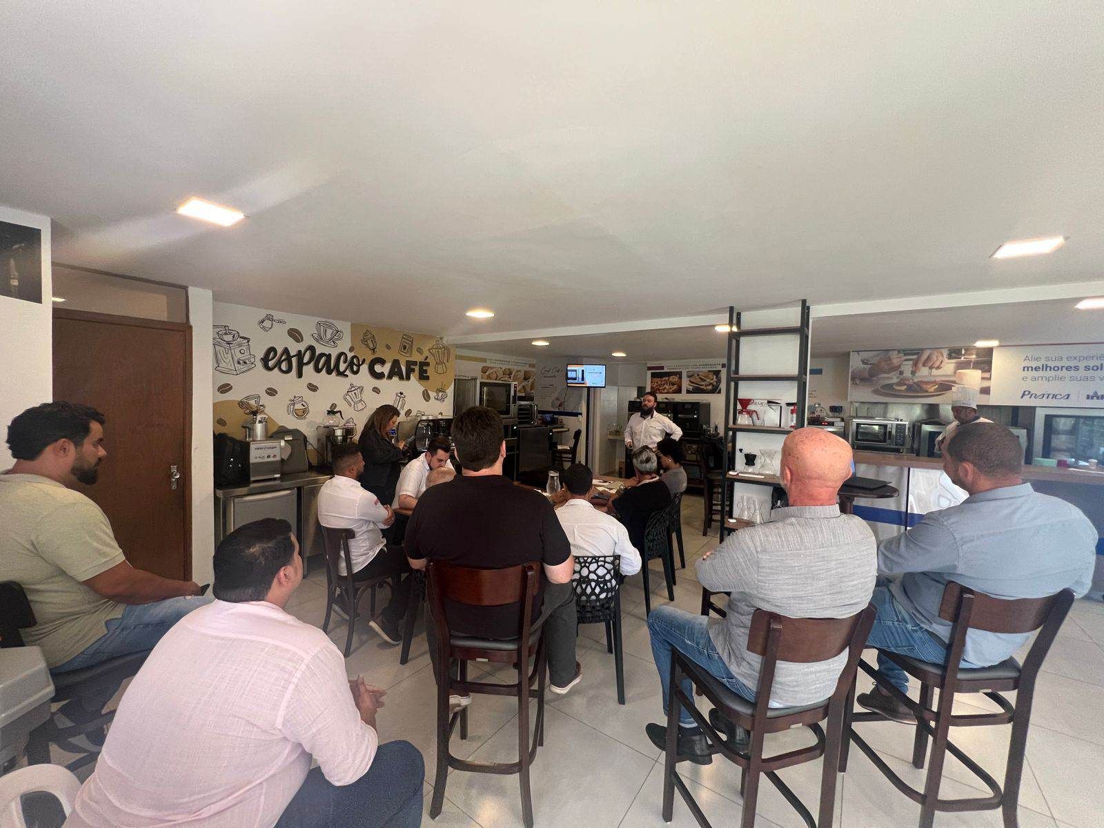Um grupo de pessoas está sentado em cadeiras em um restaurante.