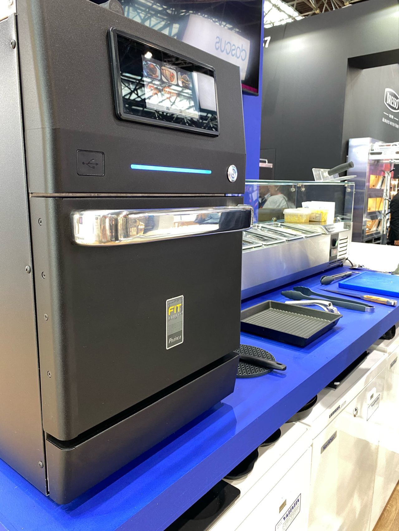 Um forno preto está sobre uma mesa azul.