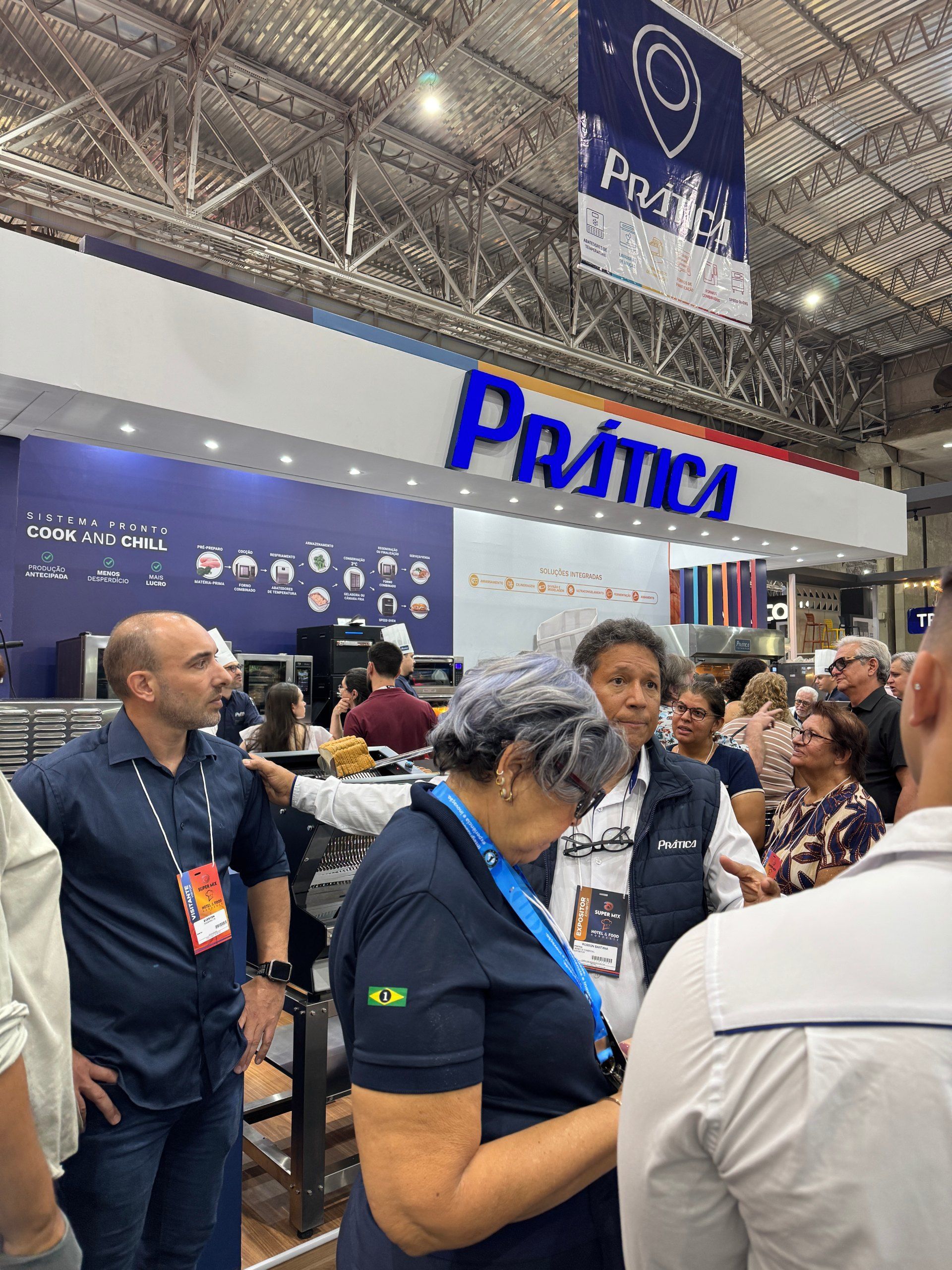 Pessoas em um estande de feira comercial com o logotipo 