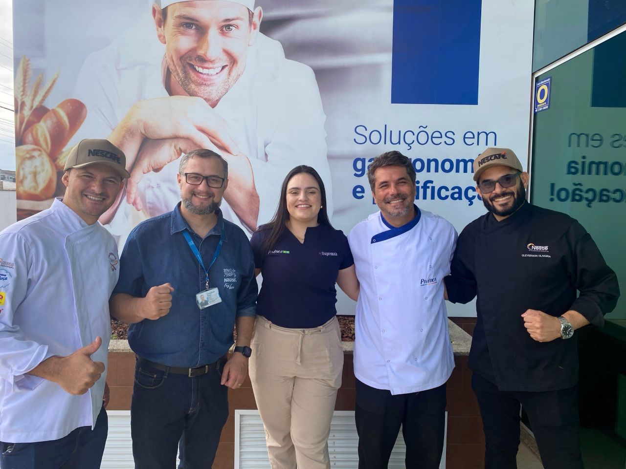 Um grupo de pessoas posando para uma foto em frente a uma placa que diz soluções em gastronomia