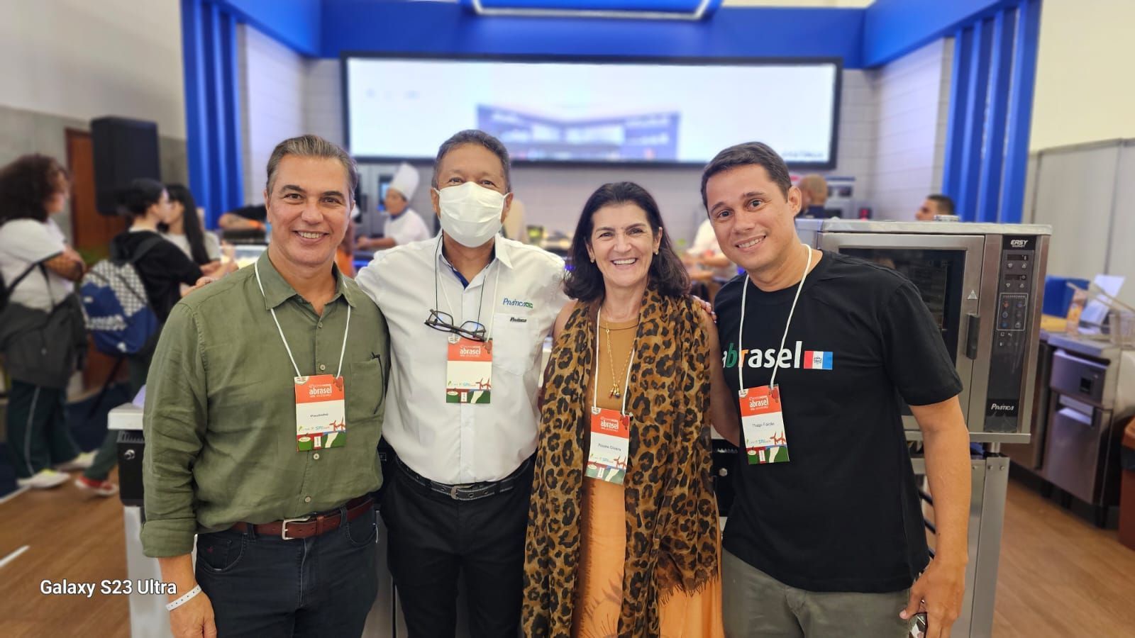 Um grupo de pessoas está posando para uma foto em uma sala.
