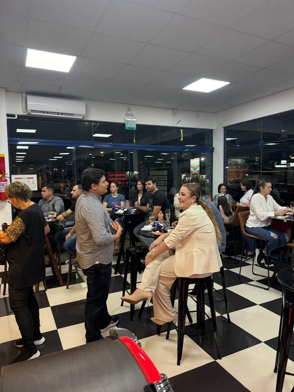 Um grupo de pessoas está sentado em mesas em um restaurante.