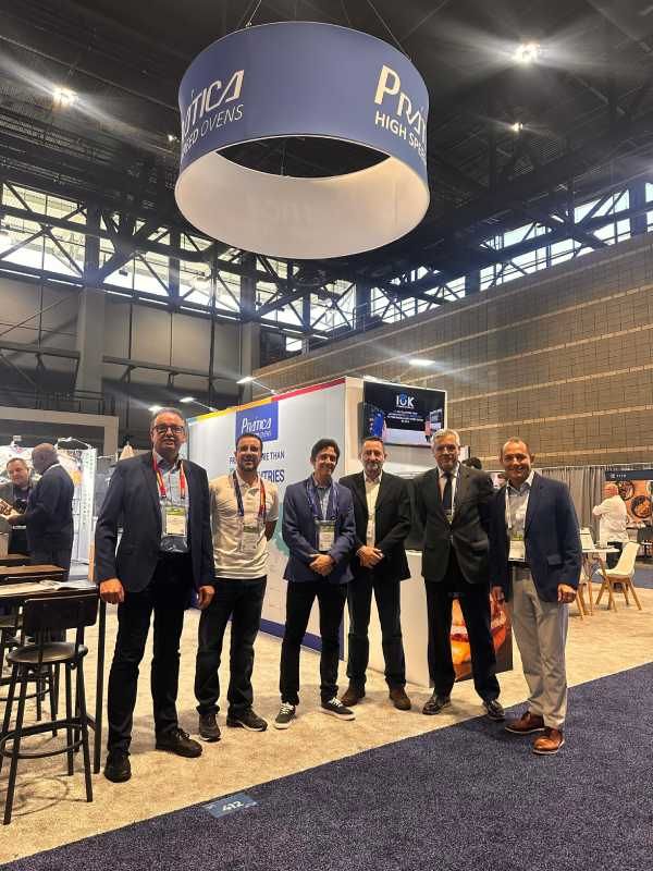 Um grupo de homens está posando para uma foto em uma convenção.
