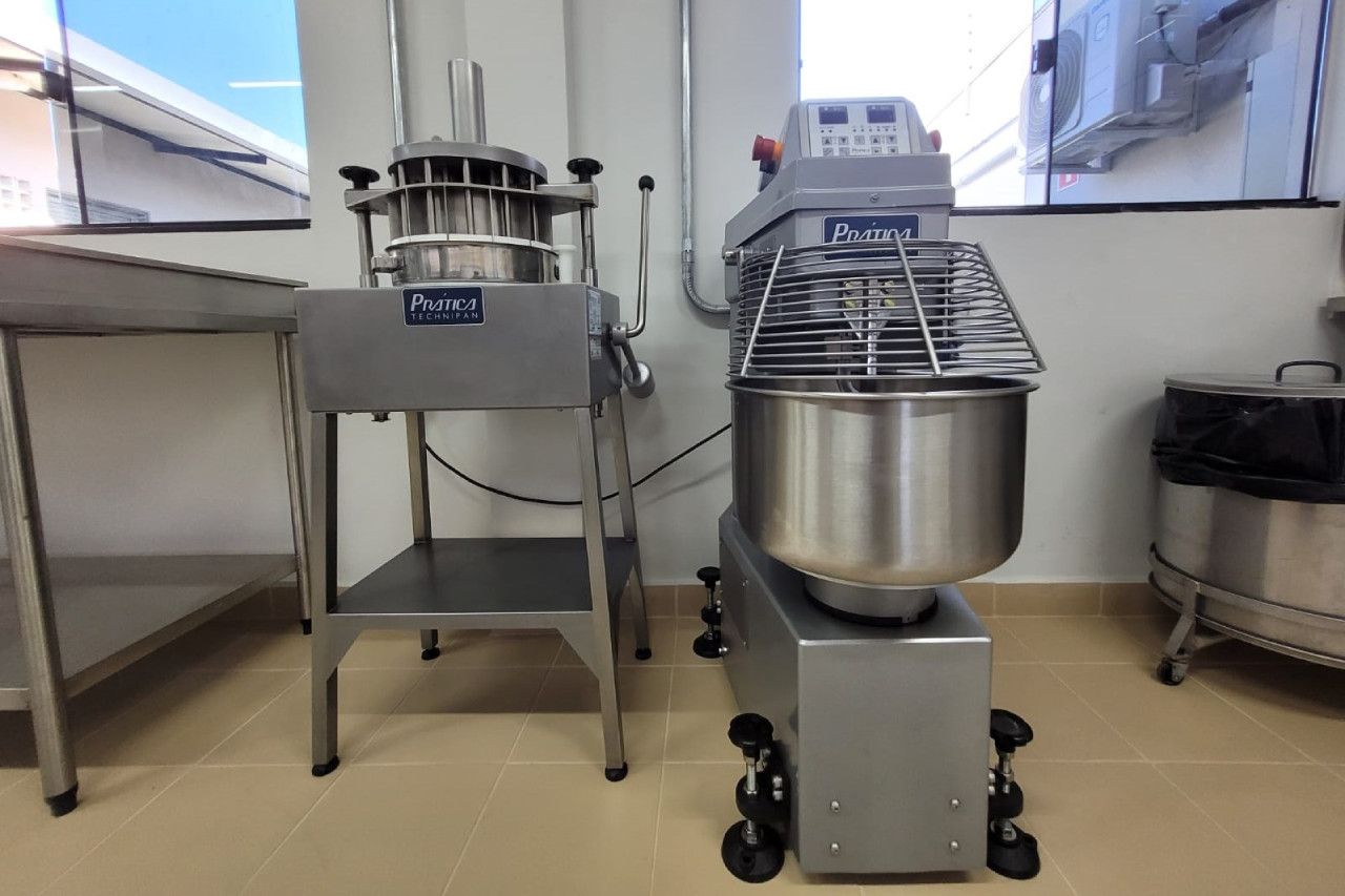 Um misturador de aço inoxidável fica em uma cozinha ao lado de outro misturador