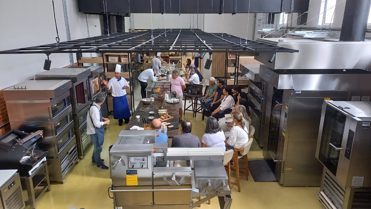 Um grupo de pessoas está sentado ao redor de uma mesa na cozinha.