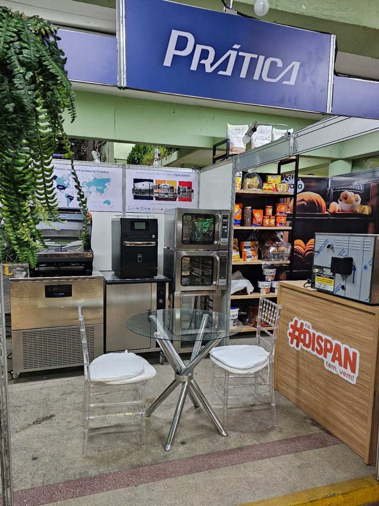 Há uma mesa e cadeiras em frente a uma placa que diz prática.