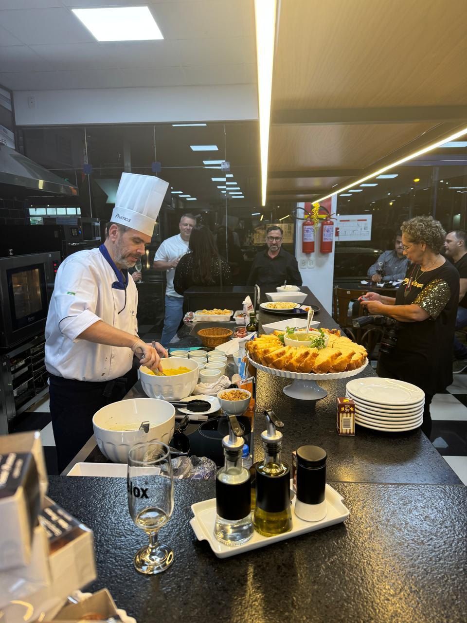 Um homem com chapéu de chef está preparando comida na cozinha.