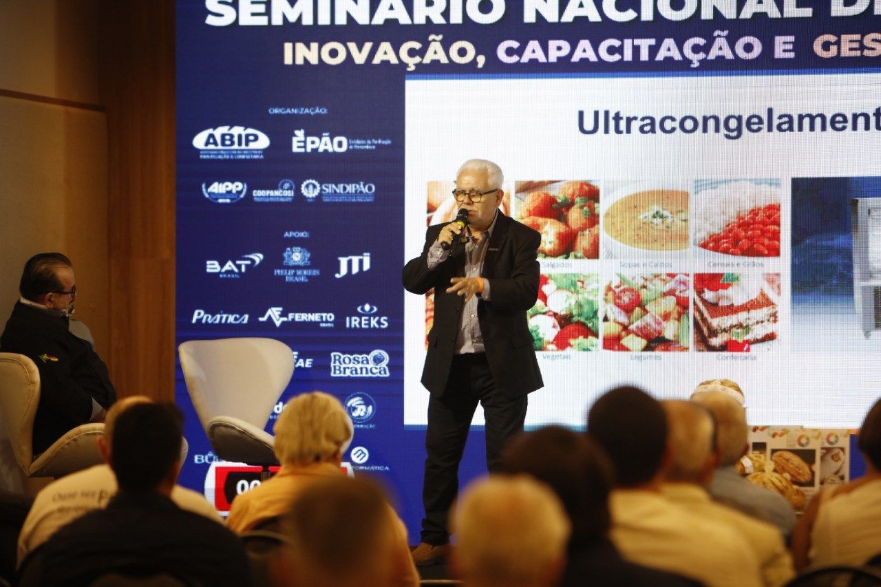 Um homem está falando em um microfone em um seminário