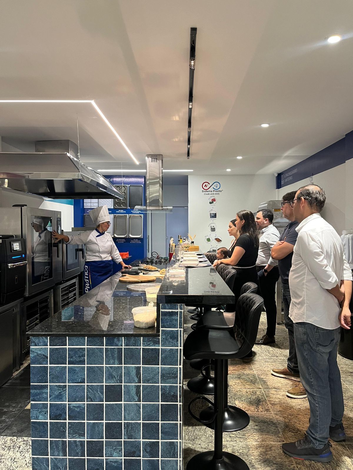 Chef de cozinha demonstrando técnicas de culinária para um público atento.