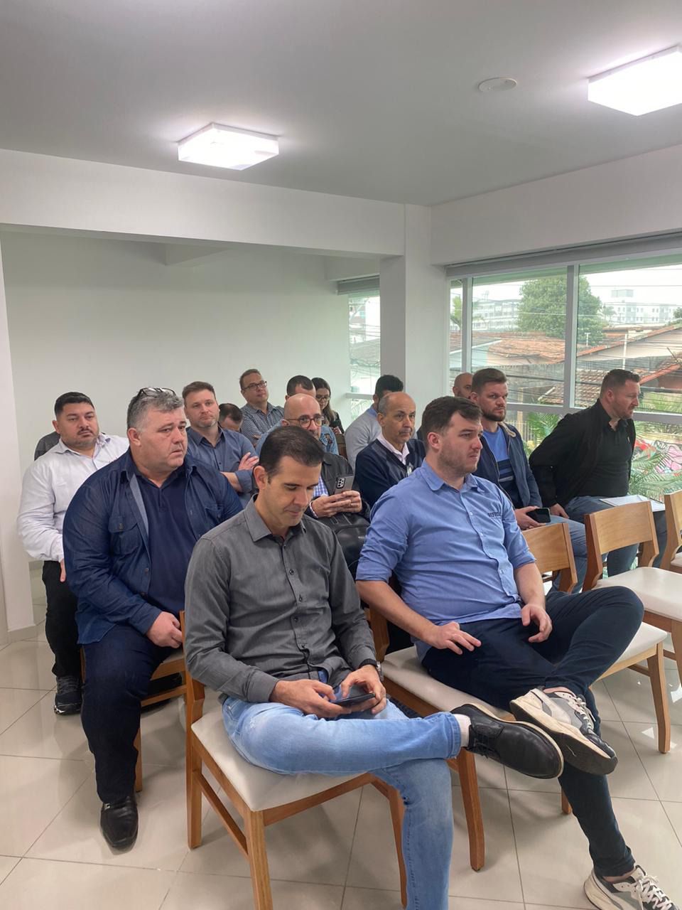 Um grupo de homens está sentado em cadeiras em uma sala.