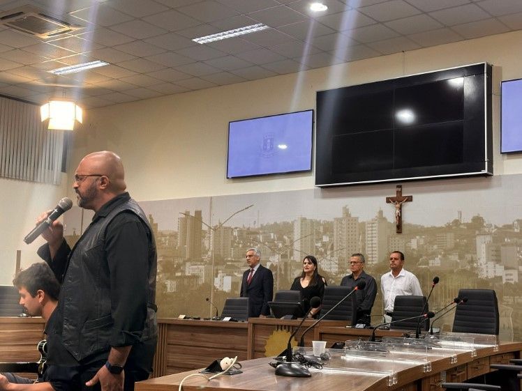 Um homem está falando em um microfone em uma sala de conferências.