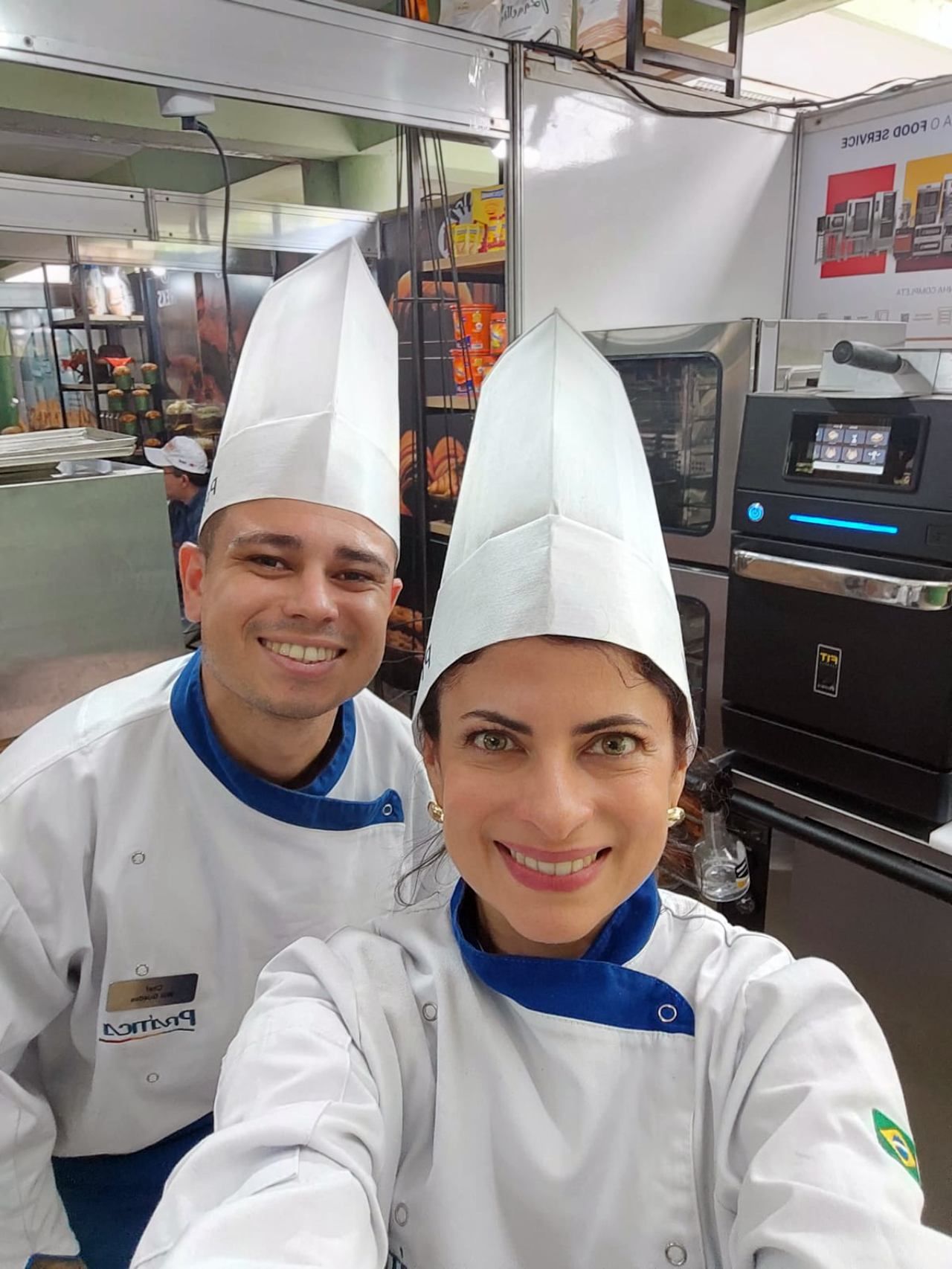 Um homem e uma mulher estão posando para uma selfie em uma cozinha.