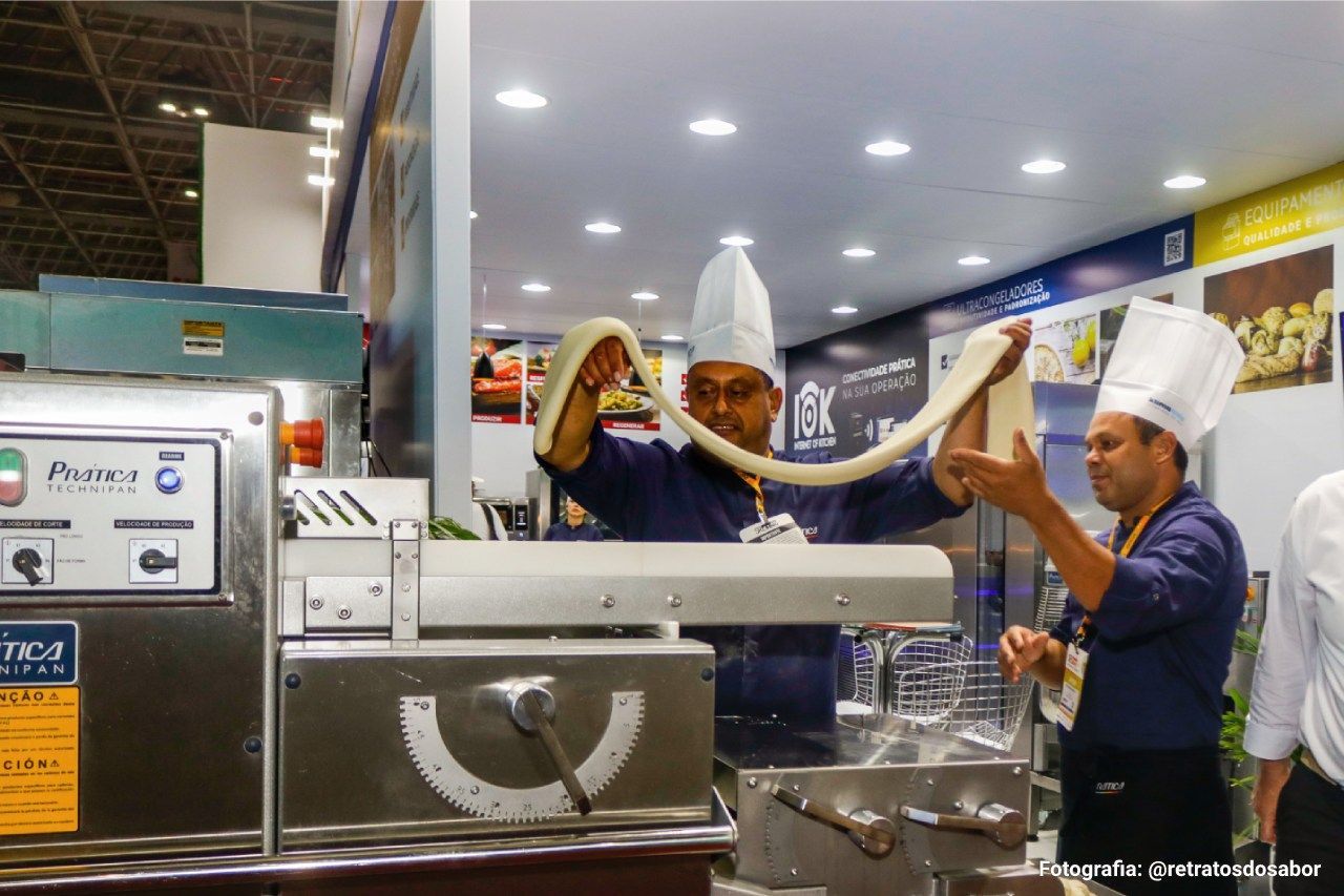 Um homem com chapéu de chef está trabalhando em uma máquina.