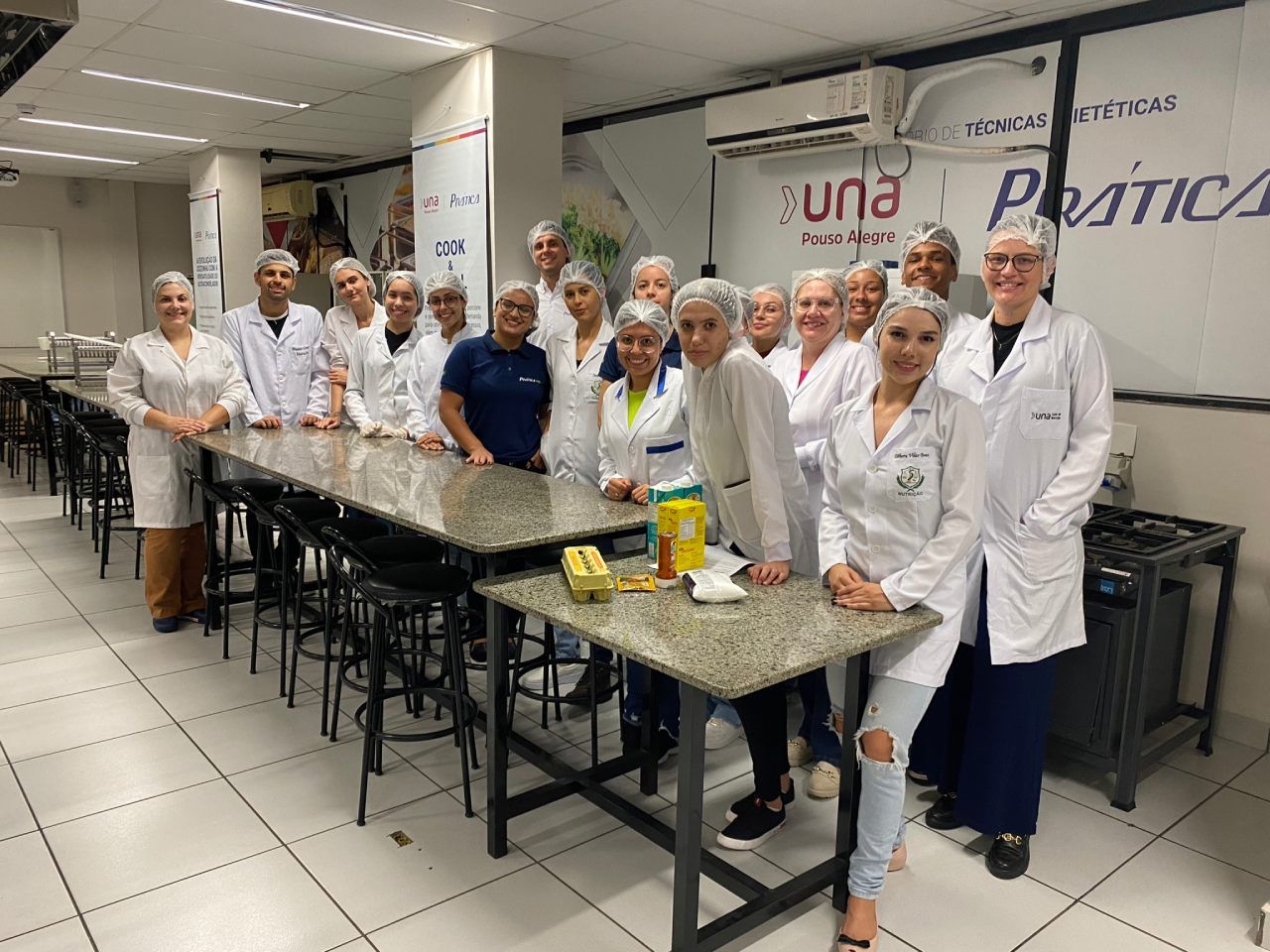 Um grupo de pessoas está posando para uma foto em uma cozinha.