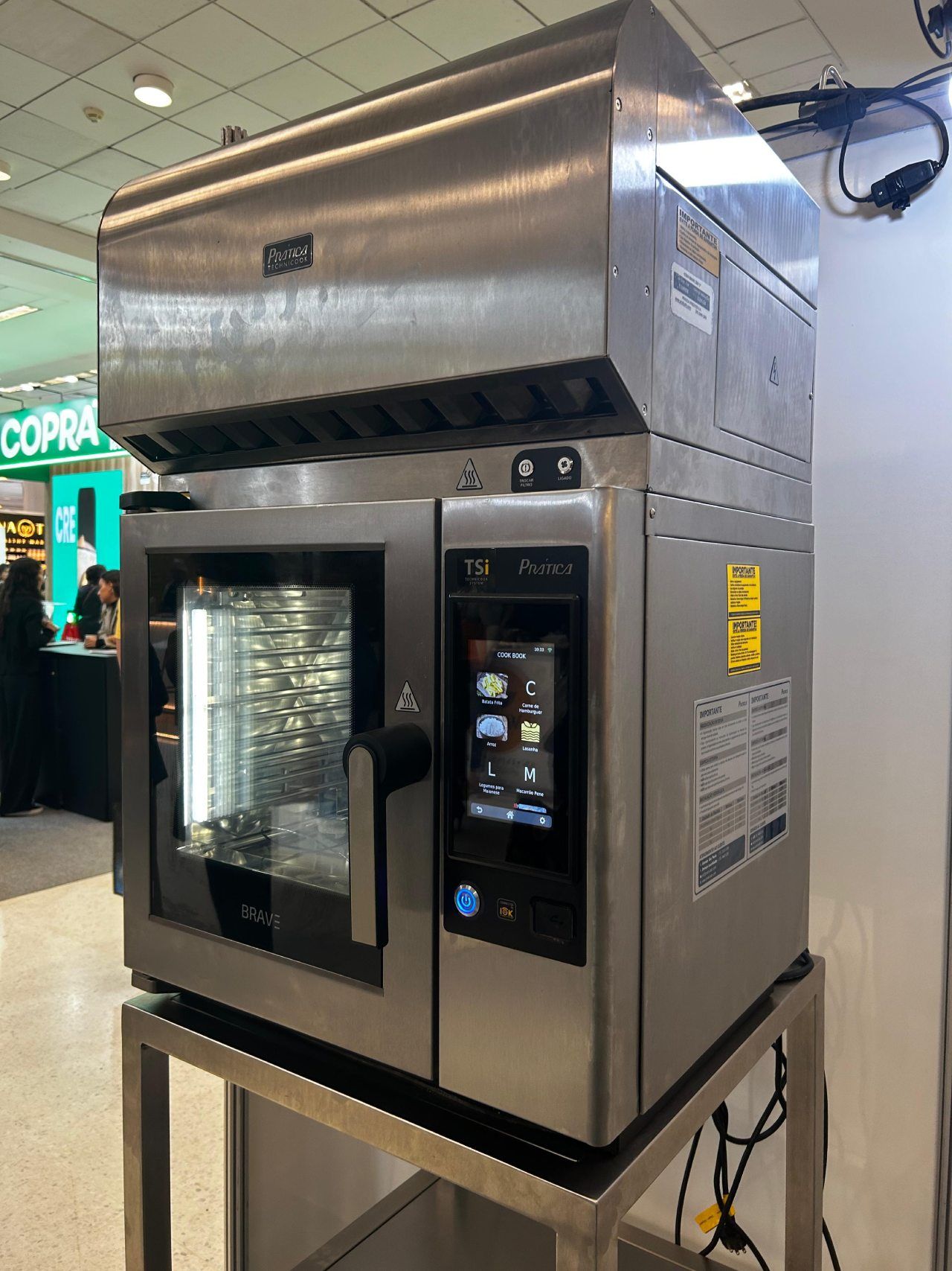 Um forno de aço inoxidável está sobre um suporte de metal.