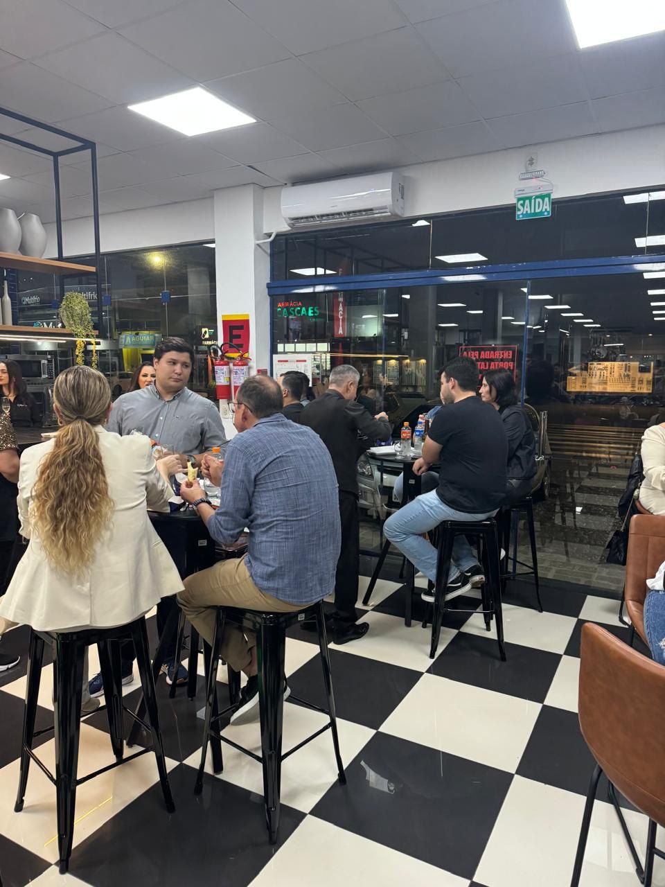 Um grupo de pessoas está sentado em mesas em um restaurante.