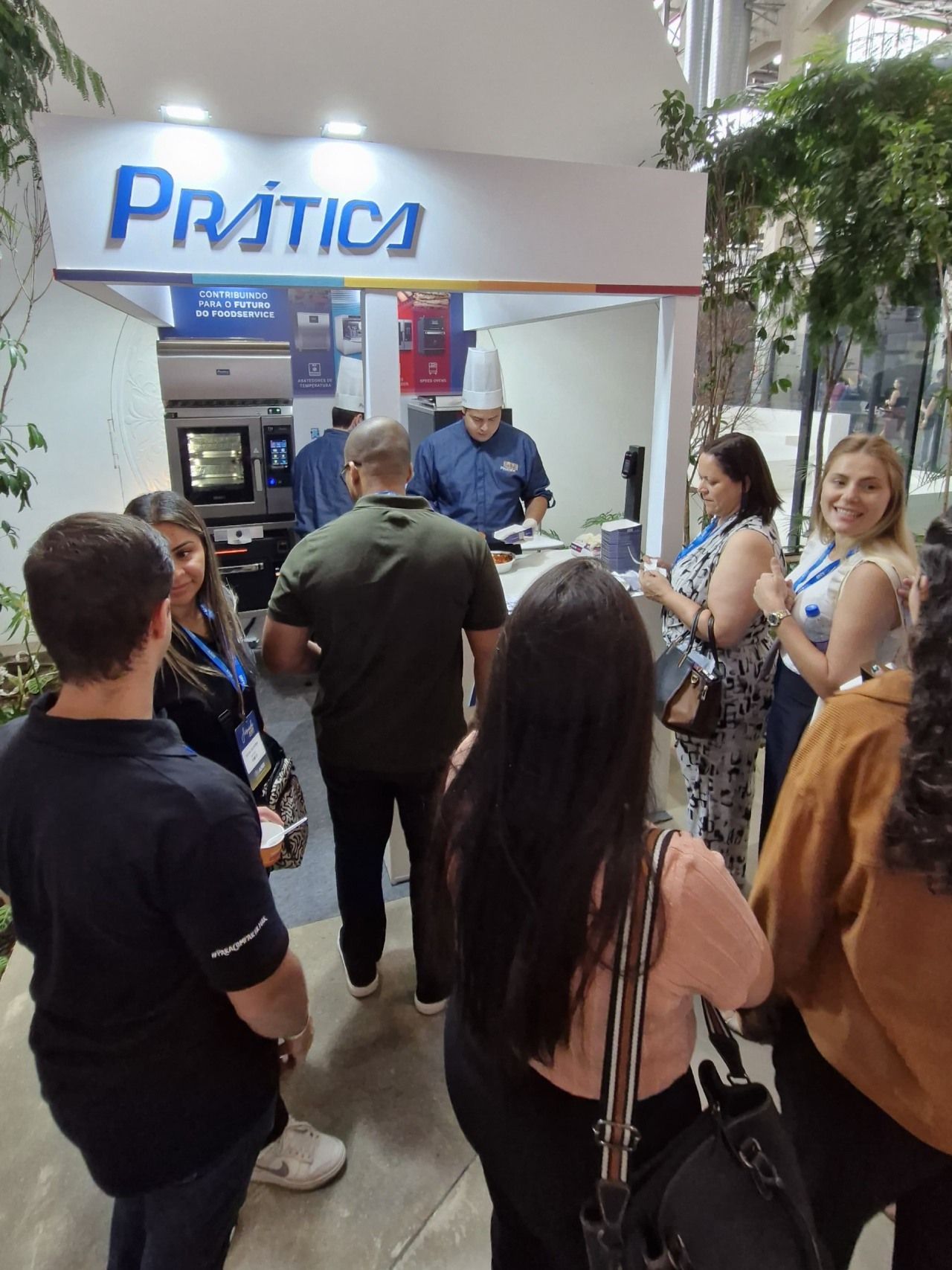 Um grupo de pessoas em pé em frente a uma placa que diz prática