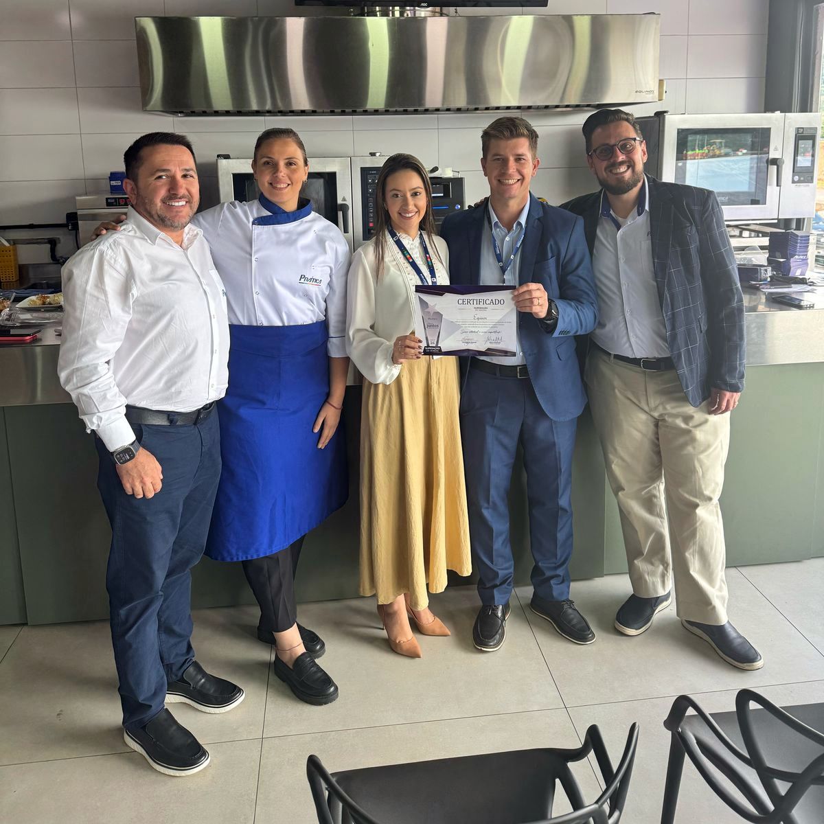 Um grupo de pessoas posando para uma foto em uma cozinha