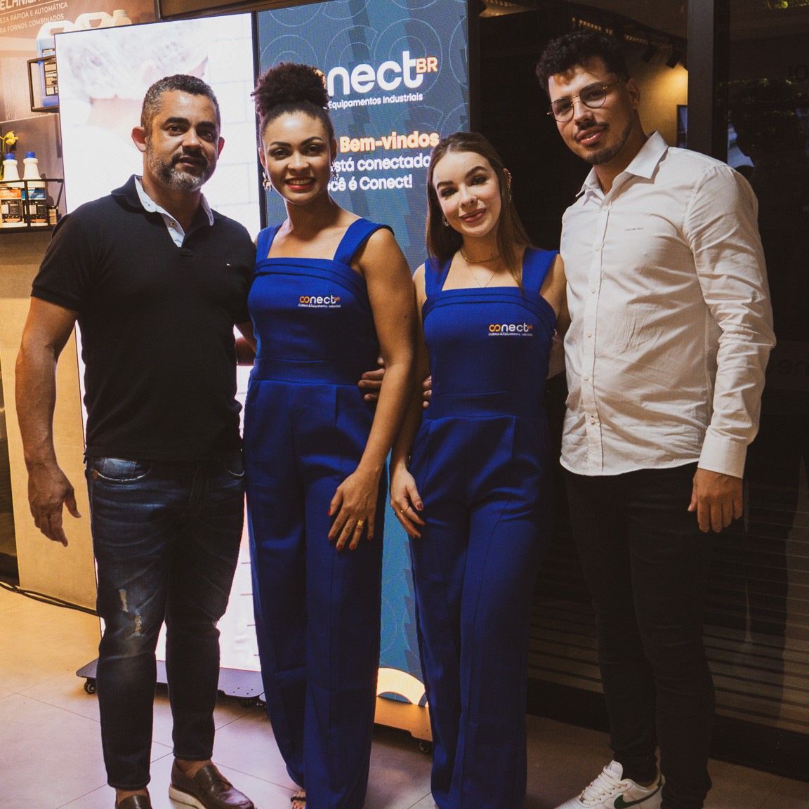 Um grupo de pessoas em pé em frente a uma placa que diz nect