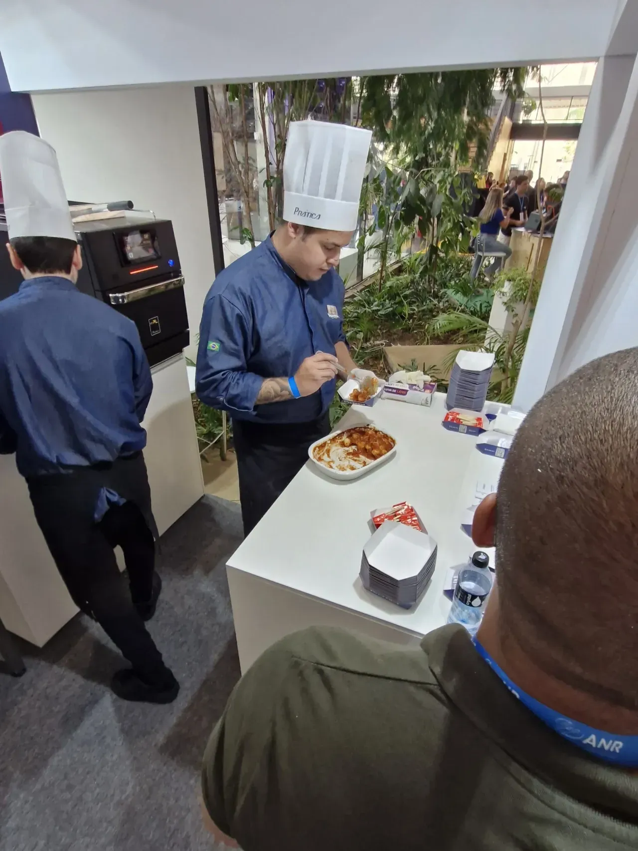 Um homem com chapéu de chef está preparando comida em um balcão
