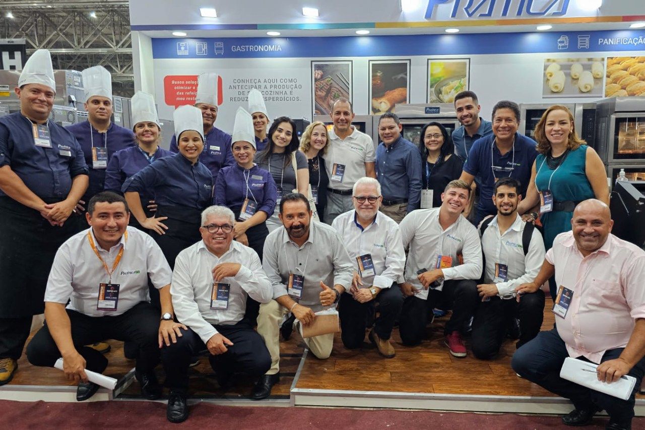Um grupo de pessoas está posando para uma foto em frente a uma cabine.