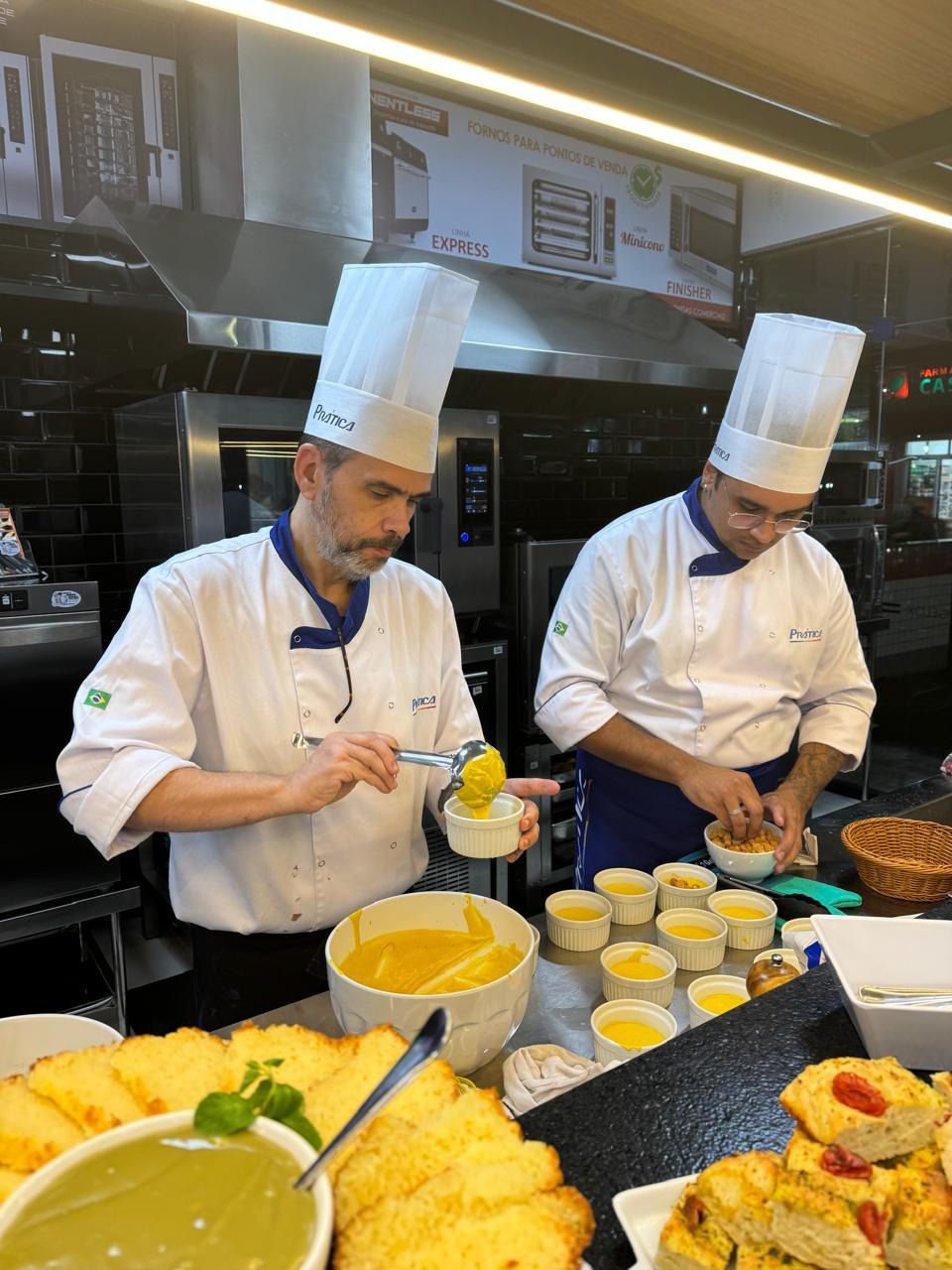 Dois chefs estão preparando comida em uma cozinha.
