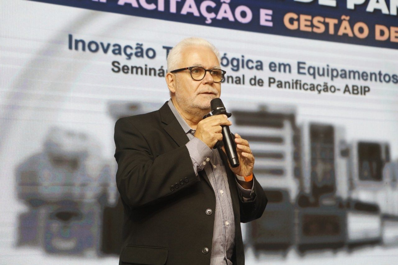 Um homem de terno está falando em um microfone