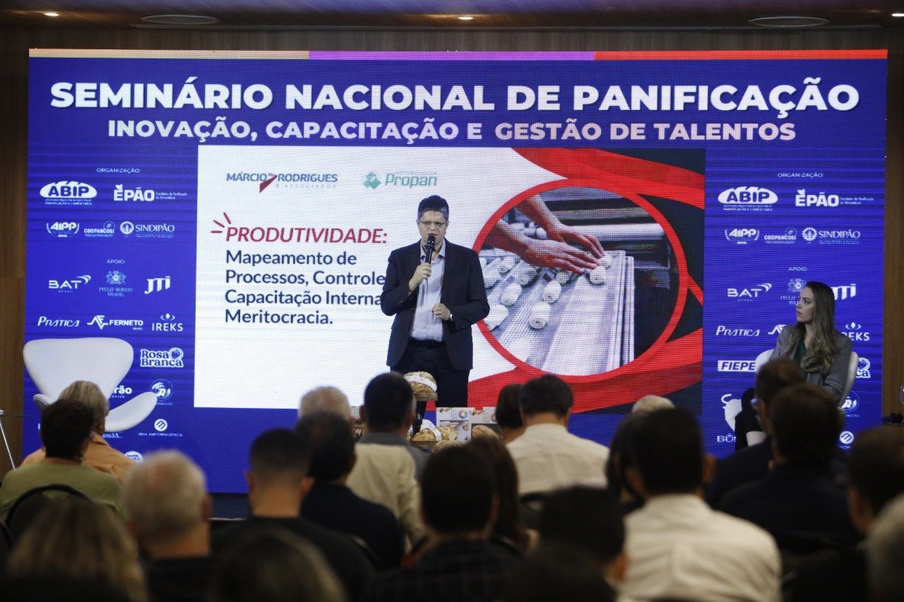 Um homem está fazendo uma apresentação para uma multidão em um seminário