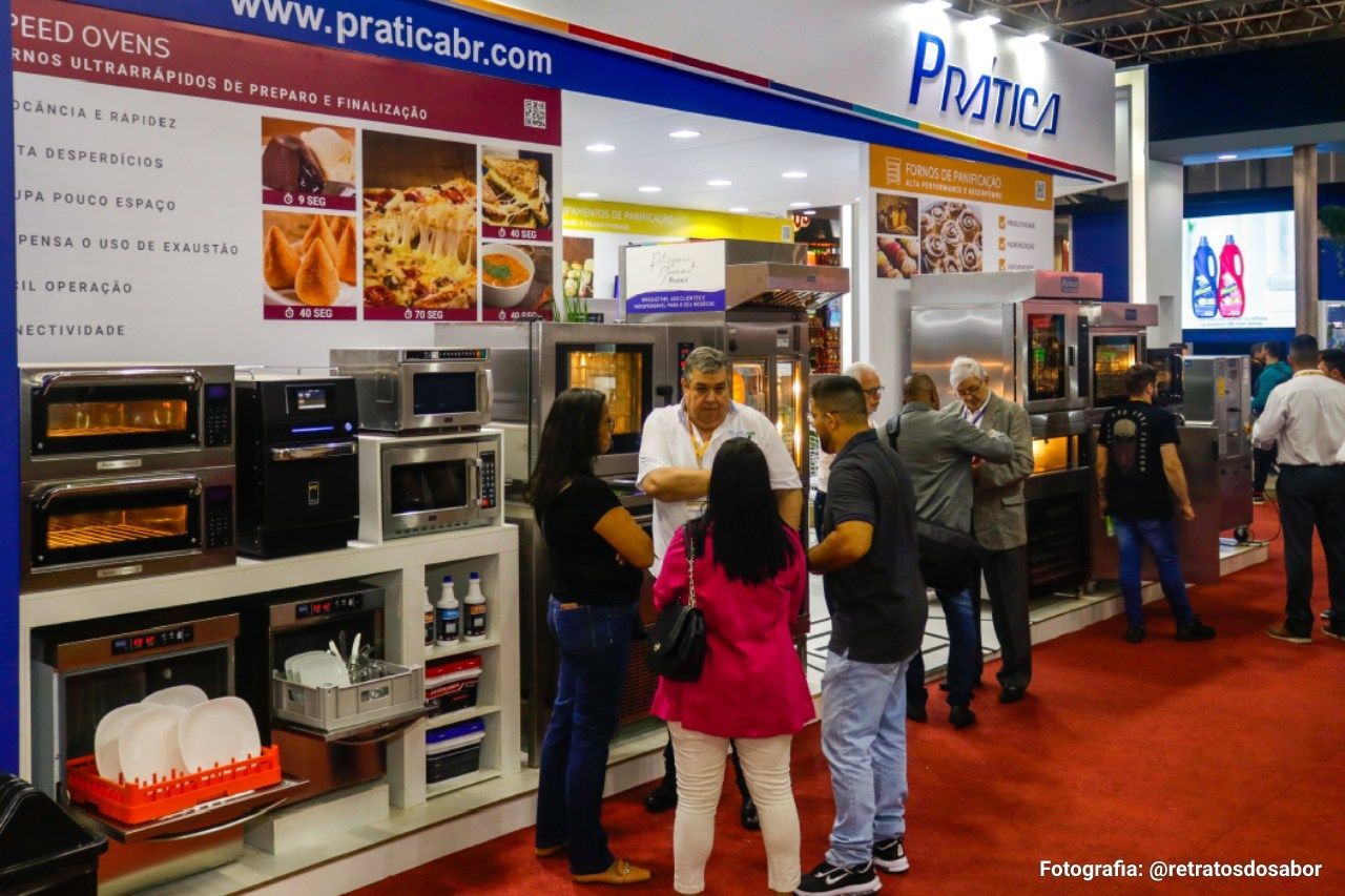 Um grupo de pessoas está em frente a uma exposição de fornos.