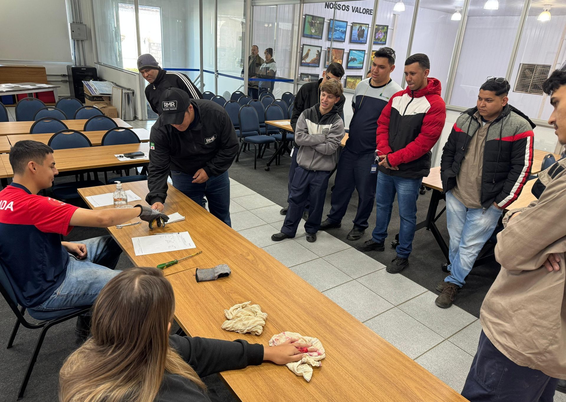 Um grupo de pessoas está em pé ao redor de uma mesa em uma sala.